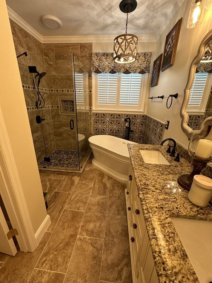 Traditional master bathroom with freestanding tub, granite vanity, and tiled shower